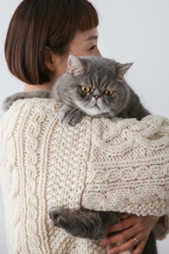 飼い主に抱っこされる猫